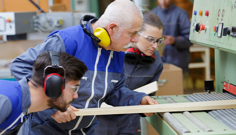 A photo showing an apprentice being trained on machinery