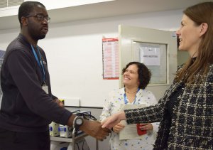 A photo showing a member of the SI Ministerial Visit Group shaking hands with an employee